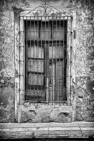 Window with closed shutter and metal grill in Puebla, Mexico